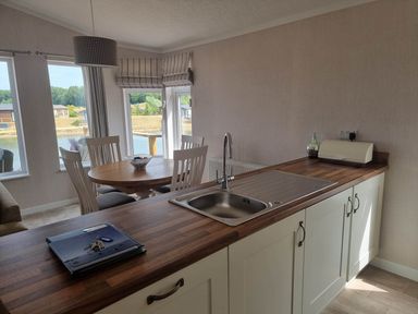 A kitchen with a sink and a dining table at Pet Friendly 2Bed Luxury Lodge in Routh HotTub Heron Lakes Luxury Lodge Park near Beverley