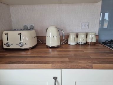 A kitchen countertop with a toaster, kettle, and storage jars labeled sugar, tea, and coffee at Pet Friendly 2Bed Luxury Lodge in Routh HotTub Heron Lakes Luxury Lodge Park near Beverley