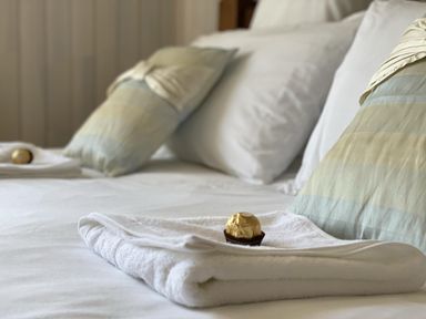 A bed with pillows and towels at Stunning Sleeps 6 Luxury Lodge Pets Mercia Marina near Willington, Derbyshire