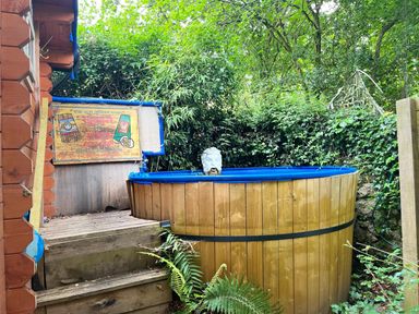 A hot tub on a wooden deck in a garden area at the property