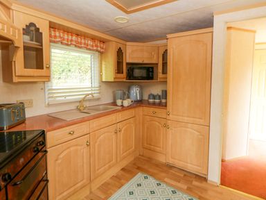 A kitchen with cabinets and a sink at Leven in Lampeter