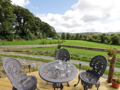 An outdoor seating area with a table and chairs at Leven in Lampeter
