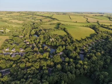 An aerial view of houses and ponds surrounded by trees at 5 Tree Tops in Dobwalls