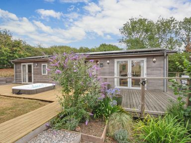 An outdoor area with a hot tub and wooden building at 5 Tree Tops in Dobwalls