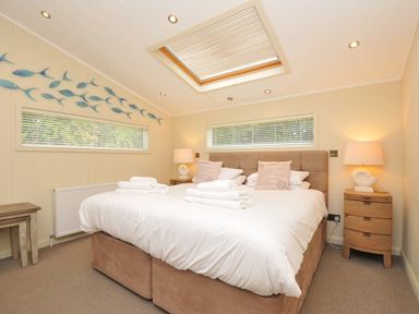 A bedroom with a double bed and fish decoration at 5 Tree Tops in Dobwalls