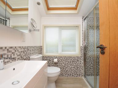 A bathroom with a sink, toilet, and shower at 5 Tree Tops in Dobwalls