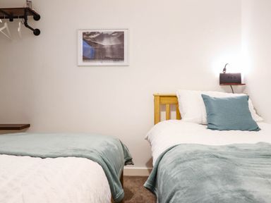 A bedroom with two beds and a shelf at 1 Glanaber Terrace