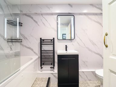 A bathroom with a bathtub, sink, and towel rail at 1 Glanaber Terrace