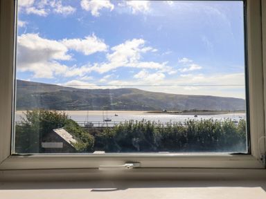A view through a window showing water and boats at 1 Glanaber Terrace