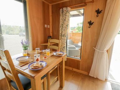 A dining room with a table set for breakfast at Oak Lodge in Brecon