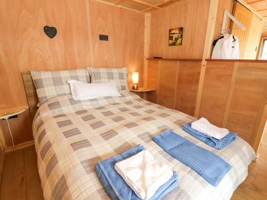 A bedroom with a bed and towels at Oak Lodge Brecon