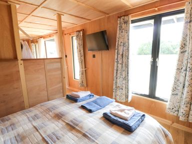 A bedroom with a bed and towels on it at Oak Lodge in Brecon