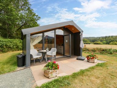 A small cabin with outdoor seating at Sycamore Lodge Brecon
