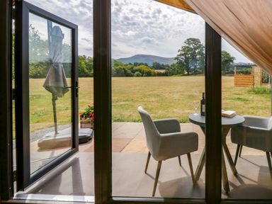 A table with chairs and a wine bottle at Sycamore Lodge Brecon