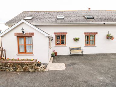 A home exterior with windows, a door, and a bench at The Stable in Haverfordwest
