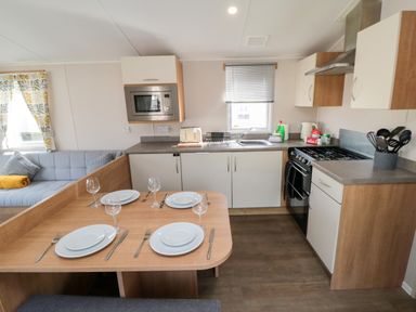 A kitchen with dining area and sofa at 14 Pines in Cayton Bay