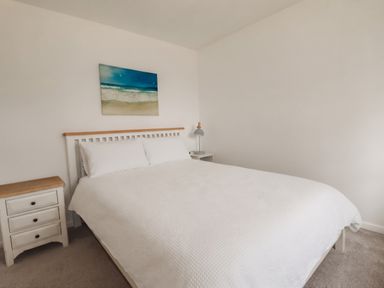 A bedroom with a bed and nightstand at Cloudbreak in Wadebridge