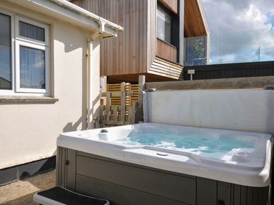 A hot tub next to a house at Cloudbreak in Polzeath