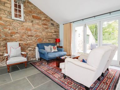 A living room with a blue sofa and stone walls at The Homestead 