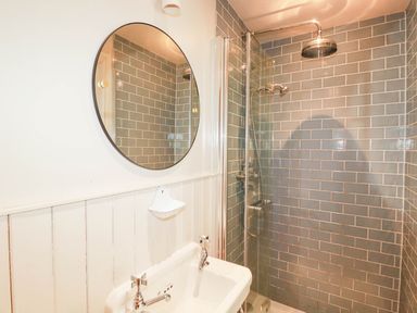 A bathroom with a mirror and shower at The Homestead 