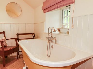 A bathroom with a bathtub and a chair at The Homestead