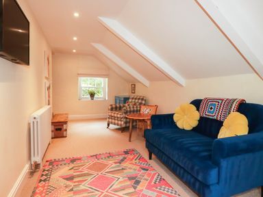 A sitting room with a blue sofa and television at The Homestead 