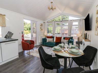 A living room with a sofa and dining area at 73 Cildraeth in New Quay
