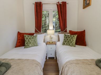 A bedroom with two beds and a lamp on a nightstand at 73 Cildraeth in New Quay
