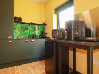 A kitchen with appliances including a refrigerator and microwave at The Hyde, Tazamble cottage, Launceston