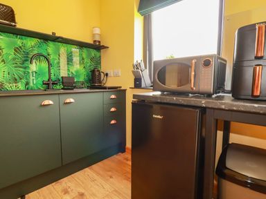 A kitchen with cabinets, a sink, a kettle, a microwave and a refrigerator at The Hyde, Tazamble cottage in Launceston