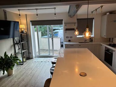 A kitchen with island seating and sliding doors at The Old Barn in Manchester