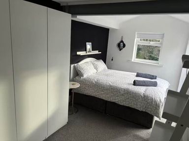A bedroom with a bed and wardrobe at The Old Barn in Manchester