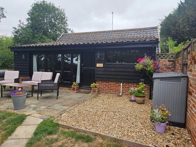 An outdoor patio area with a table and seating at Lily's Cottage Suffolk Sleeps 2 with Pets Mendlesham Green near Stowmarket