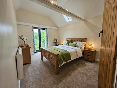 A bedroom with a bed and nightstands at Lily's Cottage Suffolk Sleeps 2 with Pets in Mendlesham Green near Stowmarket