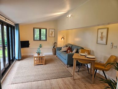 A living room with a sofa and dining table at Lily's Cottage Suffolk Sleeps 2 with Pets Mendlesham Green near Stowmarket