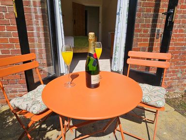 A table with a champagne bottle and drinks at Lily's Cottage Suffolk Sleeps 2 with Pets in Mendlesham Green near Stowmarket