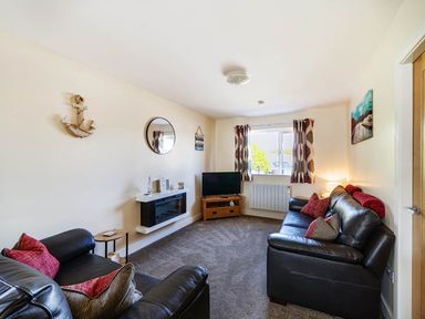 A living room with a television and sofa at Seaside Chalet Retreat in Bridlington