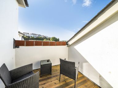 A balcony with two chairs and a table at Apartment Sleeps 4 with Balcony and Parking in Kingsbridge