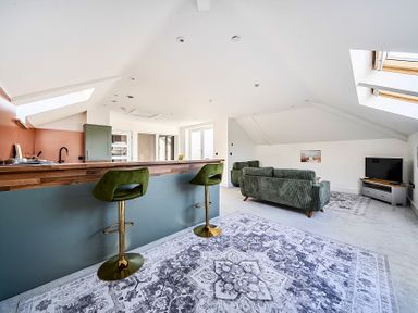 A living room with a sofa and bar stools at Apartment Sleeps 4 with Balcony and Parking in Kingsbridge