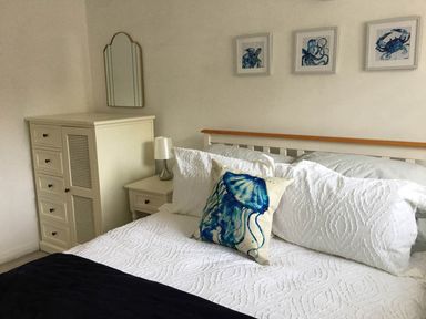 A bedroom with a bed and artwork on the wall at Torpoint Apartment Sleeps4 Seaside Parking in Downderry