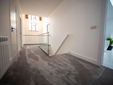 A hallway with a staircase and light fixture at Stunning 3 Bed Converted Village Hall Near Kelso Nenthorn near Kelso