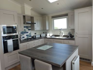 A kitchen with cabinetry and appliances at 2 Bedroom Sleeps 4 Lodge Smart Tv Hot tub Dogs Ok near Lochwinnoch