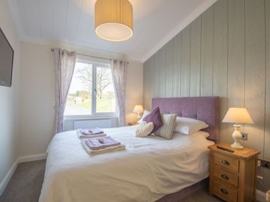 A bedroom with a bed and television at 2 Bedroom Sleeps 4 Lodge Smart Tv Hot tub Dogs Ok near Lochwinnoch