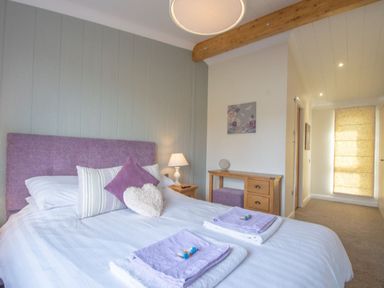 A bedroom with a double bed and side table at 2 Bedroom Sleeps 4 Lodge Smart Tv Hot tub Dogs Ok near Lochwinnoch