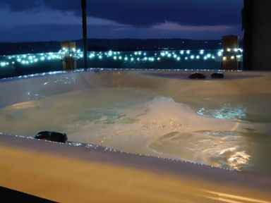 A hot tub with water and bubbles near an outdoor view at 2 Bedroom Sleeps 4 Lodge Smart Tv Hot tub Dogs Ok near Lochwinnoch