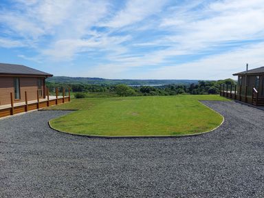An outdoor area with two cabins and a lawn at 2 Bedroom Sleeps 4 Lodge Smart Tv Hot tub Dogs Ok near Lochwinnoch