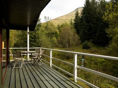 A balcony with table and chairs at a 2 bedroom lodge with free WiFi and mountain view near Crianlarich