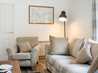 A living room with a sofa and armchair at 2 bedroom lodge with free WiFi and mountain view near Crianlarich