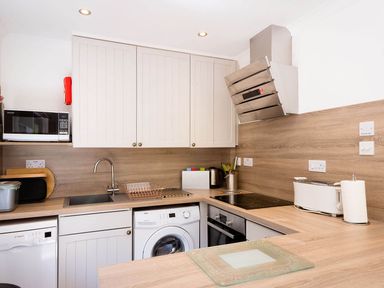 A kitchen with microwave and washing machine at 2 bedroom lodge with free WiFi and mountain view near Crianlarich