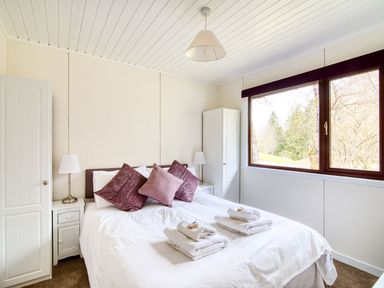A bedroom with a bed and wardrobe at 2 bedroom lodge with free WiFi and mountain view near Crianlarich